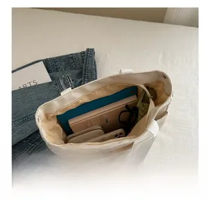 Internal view of beige canvas tote bag showing large capacity storage and multi-pockets