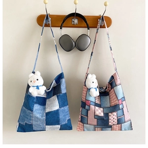 Detail view of large patchwork tote bags with plaid patterns and plush rabbit charms