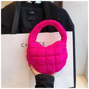 Close-up of rose pink quilted bubble bag with puffy texture and integrated handle
