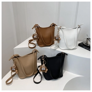 Détails des sacs seaux en quatre couleurs avec cuir texturé et breloques en peluche