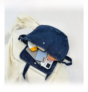 Spacious blue denim crossbody bag with flap and metal snap button for daily essentials