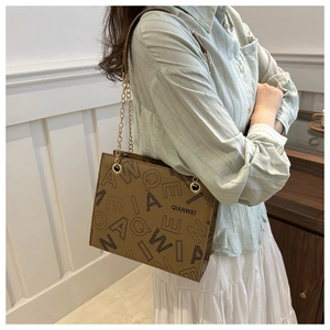 Detail of QIANWEI brown shoulder bag showing texture, large logo, and gold chain strap