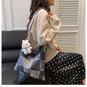 Close-up of a large grey plaid tote bag with a cute white bunny plush doll keychain