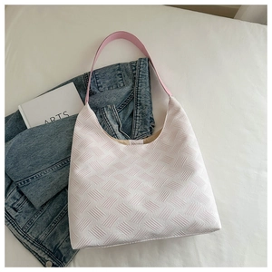 Detailed view of the light pink bubble texture fabric and leather strap on the tote bag