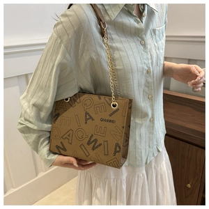 Detail view of the brown leather shoulder bag featuring vintage geometric letter prints