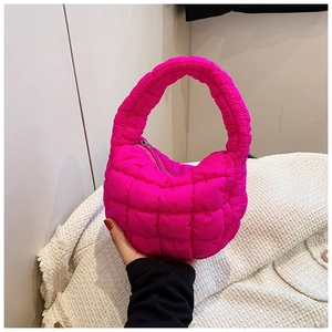 Detail of pink quilted cloud bag featuring soft puffy texture and mini top handle