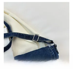 Detail of adjustable silver buckle on a dark blue denim crossbody bag strap