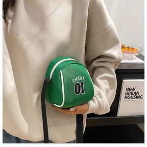 Close-up of mini green canvas crossbody bag with white China 01 lettering and zipper