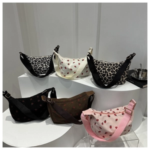 Vue détaillée de divers sacs à bandoulière demi-lune en velours côtelé à motifs