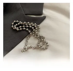 Close-up of polished silver metal bead chain hardware for a stylish shoulder bag