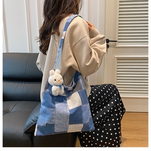 Detail of blue denim patchwork tote bag with a cute white bunny plush pendant charm