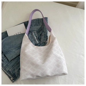 Close-up of white bubble textured fabric tote with purple leather straps and large space
