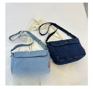Close-up of two denim messenger bags in light and dark blue with adjustable straps