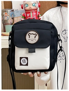 Close-up of canvas crossbody bag with cute bear patch and flap pocket detail
