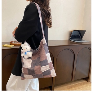Detail of a large canvas tote bag with geometric patchwork and a cute bunny pendant