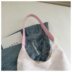 Close-up of woven white shoulder bag with pink leather strap and side metal buckle