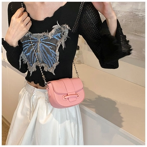 Pink lychee texture saddle bag shown on a model with decorative ring buckle and chain strap