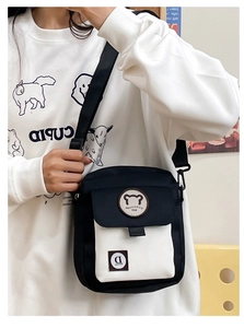 Detail of cute bear canvas crossbody bag with adjustable strap and front pocket design