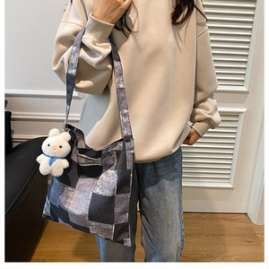 Close-up of a large checkered tote bag with a cute plush bunny pendant on the side