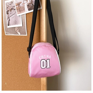Detail of pink canvas crossbody bag featuring white CHINA 01 lettering and black strap