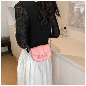 Pink saddle crossbody bag with pebbled leather texture and silver chain strap