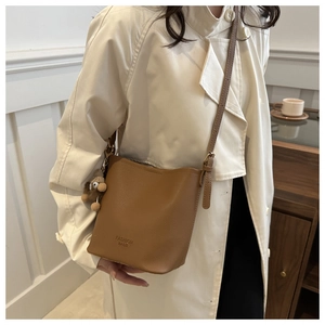 Sac seau marron en cuir grainé avec un porte-clés décoratif en peluche pour femme