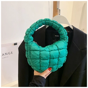 Detail of bright green quilted bubble handbag with unique puffy texture and zipper