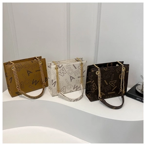 Three elegant vintage shoulder bags in ochre, cream, and brown with golden chain straps