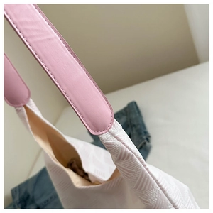 Close-up of white bubble texture tote bag with pink leather strap and neat stitching