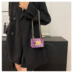 Dettaglio della mini borsa a tracolla leopardata viola con catena dorata e chiusura