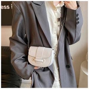 Detailed view of white lychee grain leather mini crossbody bag with gold ball chain strap