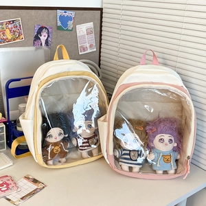 Close-up of itabags in yellow and pink with clear PVC windows showing plush dolls