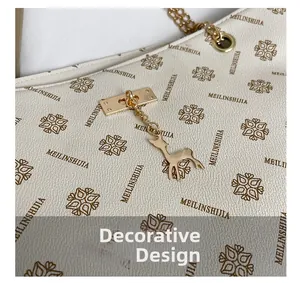 Detail der Monogramm-Ledertasche mit goldenem Hirsch-Anhänger und Metallkette