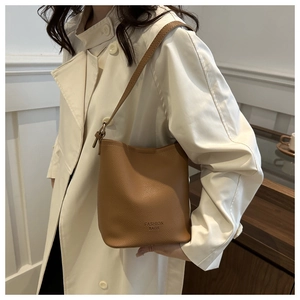 Vue détaillée de la texture du cuir grainé litchi marron sur ce sac seau élégant et chic