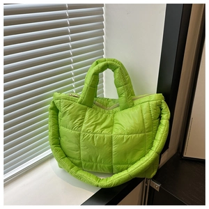 Detail of neon green puffer tote bag featuring square quilted pattern and thick padded handles