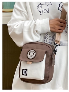 Detail of cute bear patch and adjustable strap on a brown canvas crossbody bag