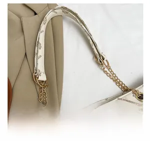 Detailansicht der braunen Monogramm-Tragetasche mit goldener Kette und glattem Leder