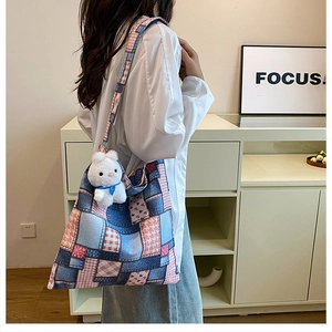 Detail of patchwork plaid tote bag with cute plush bunny charm and printed heart patterns