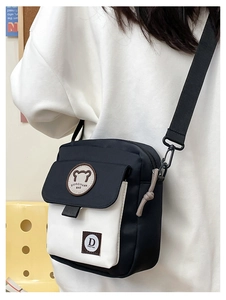 Lifestyle shot of a cute contrast color crossbody bag with bear logo and adjustable strap