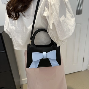 Vintage black crossbody handbag for women featuring a stylish large light blue leather bow