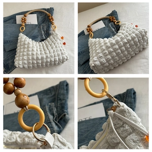 Detail of white bubble texture fabric with brown wooden bead handle and golden ring