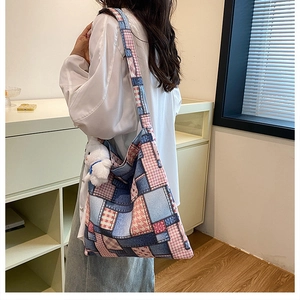 Detail of checkered patchwork tote bag with cute white plush bunny charm on shoulder