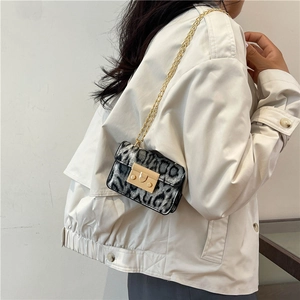 Elegante borsa a tracolla leopardata con catena dorata indossata da una modella chic