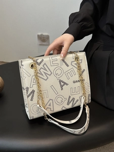 Chic beige shoulder bag with bold letter prints and a leopard pattern texture detail