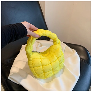 Detail view of bright yellow quilted bubble bag made of fluffy nylon with zip closure