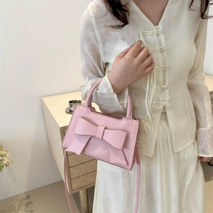 Pink vintage satchel bag with oversized bow detail and top handle for women