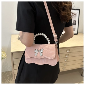Detail of light pink marble textured bag with pearl handle and silver bow buckle