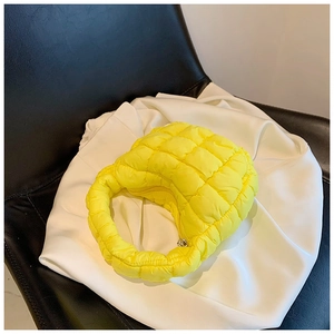 Detail of lemon yellow quilted cloud handbag featuring fluffy texture and metal zipper closure