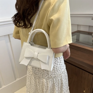 Retro white crossbody handbag with large 3D bow accent and top handle for women