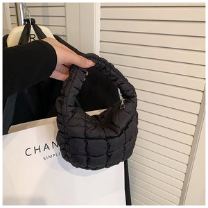 Detail of black quilted cloud handbag texture and soft puffer fabric handle on a black tote